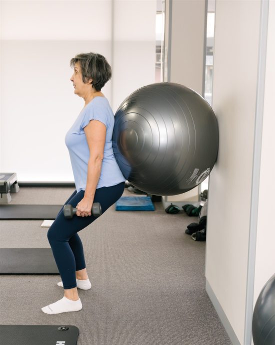 Pilates squatting with fit ball
