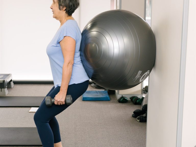 Pilates squatting with fit ball